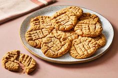 peanut butter cookies on a plate next to two pieces of the same biscuits