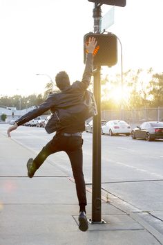 a man jumping up into the air near a street light