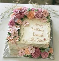 a birthday cake decorated with pink and orange flowers