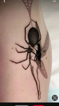 a spider tattoo on the back of a woman's arm, with an image of a