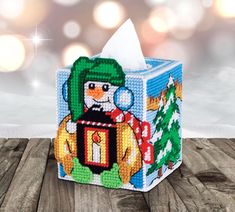 a christmas themed tissue box with a snowman on it and a candle in the middle