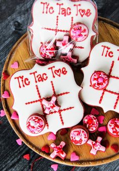 three decorated cookies on a plate with red and white icing in the shape of tic taco to toe