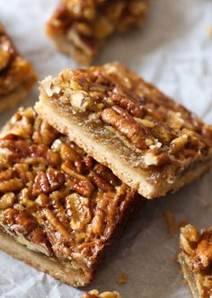 three pieces of pecan bar sitting on top of paper