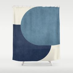 a blue and white shower curtain with an abstract design on the bottom, in front of a gray background