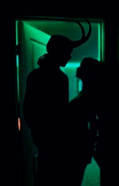 two people are standing in the dark with horns on their heads