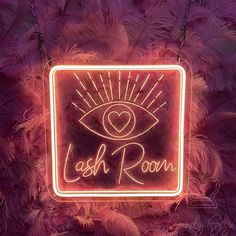 a neon sign that says, lashes room with an eyeball in the center and pink feathers around it