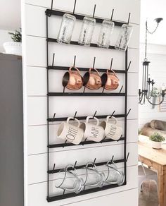 a wall mounted rack with cups and mugs on it