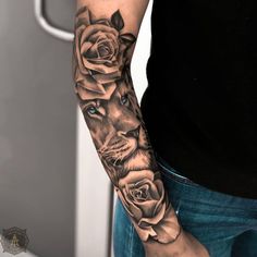 a man's arm with roses and a lion tattoo on his left arm, which is black and grey