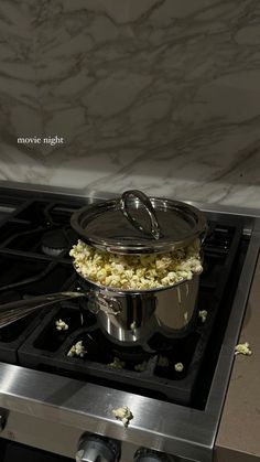 a stove top with a pot on it and some food in front of the burner