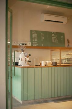 a coffee shop with green walls and counters