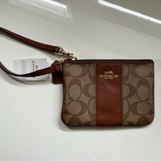 Brown/Tan Coach Wristlet, Style F52850. Brand New, Never Used, With Tags. Care Instructions Included. About 6 Inches Wide And 4 Inches Tall (See Pics). Does Not Include Official Coach Box. Zip Top, 2 Credit Card Slots Interior. Let Me Know If You Have Any Questions! Coach Brown Coin Purse For Everyday, Brown Clutch Pouch With Wrist Strap, Brown Pouch With Wrist Strap For Daily Use, Brown Wristlet For Everyday Use, Coach Brown Wristlet With Zipper Closure, Brown Coach Pouch Clutch, Brown Wallet With Wrist Strap Pouch, Brown Handheld Wristlet With Zipper Pouch, Elegant Brown Wristlet With Removable Pouch