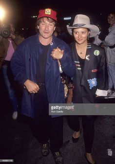 a man and woman in cowboy hats are walking through the crowd at an outdoor event