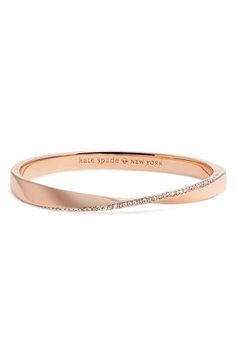 a rose gold bang bracelet with diamonds on the side and an inscription that says, kate spade