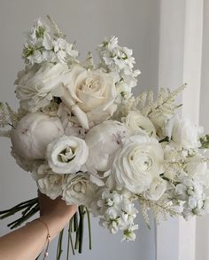 a woman holding a bouquet of white flowers