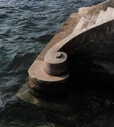 a concrete bench sitting next to the ocean