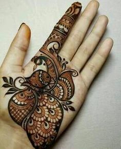 the hand is decorated with henna designs on it's palm, and has an intricate