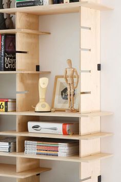 a book shelf filled with lots of books next to a vase and other items on top of it