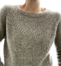 a woman wearing a sweater with holes on it