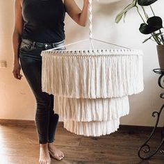 a woman standing next to a white chandelier