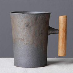 a large gray cup with a wooden handle