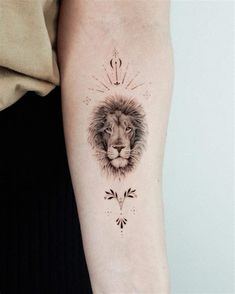 a lion tattoo on the left arm with an arrow in it's middle finger