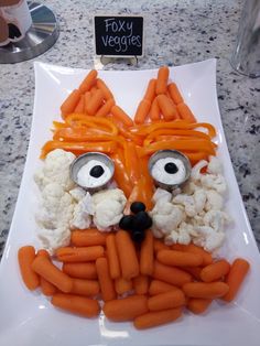 a plate with carrots and cauliflower in the shape of a face on it