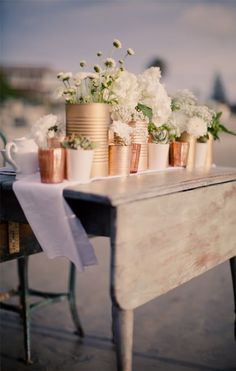 a table topped with vases filled with white flowers