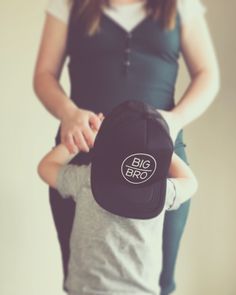 a woman holding a child wearing a hat