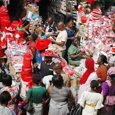 a group of people standing in front of a store filled with lots of red and white items