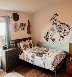 a bed room with a neatly made bed and a wall mural on the wall behind it