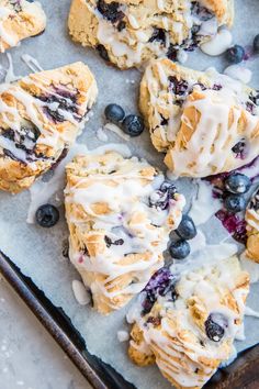 blueberry scones with icing on a baking sheet