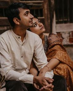 a man sitting next to a woman on the ground