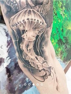 a man's leg with a tattoo on it that has a jellyfish in the water