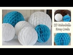 blue and white honeycombs are arranged on a table with paper balls in the background