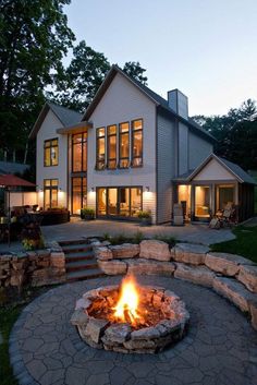 a fire pit in front of a large house