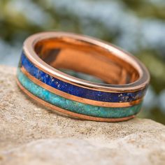 This beautiful, blue men's wedding band features two complementary materials. Genuine lapis lazuli is dark and masculine while solid, Kingman turquoise has a lighter hue. Bisected by a perfectly polished pinstripe of solid gold. RING LAYOUT Ring Width: 6.5 mmRing Profile: FlatRing Finish: PolishedRing Sleeve: 14K Gold0.75 mm 14K Gold2 mm Solid Lapis Lazuli1 mm 14K Yellow Gold2 mm Solid Kingman Turquoise0.75 mm 14K Gold This ring has a comfort fit.RING FITTING:We highly recommend that you get you Gold Wedding Band For Men, Opal Wedding Band, Wedding Band For Men, Damascus Ring, Round Profile, Jewelry By Johan, Turquoise Men, Engraved Wedding Rings, Rose Gold Wedding Band