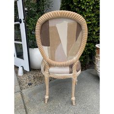 a chair made out of wicker sitting in front of a planter with potted plants