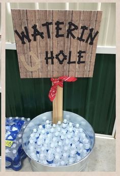 a bucket full of water and a sign that says waterin'hole on it