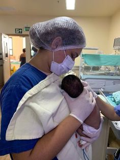 a nurse is holding a baby in the hospital