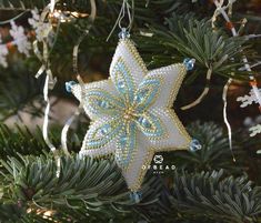 a christmas ornament hanging from a tree with blue and white decorations on it