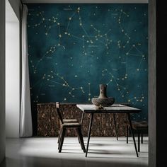 a dining room with a table and chairs in front of a wall that has stars on it