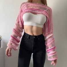 a woman in black jeans and a white top with pink crochet on it