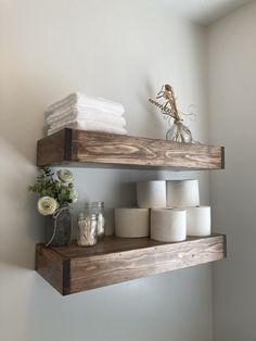 two wooden shelves holding toilet paper and other items