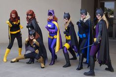 a group of women dressed up as batman and batgirl pose for a photo in front of a building