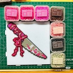 the cross stitch pattern is displayed in front of some other crafting supplies and tools