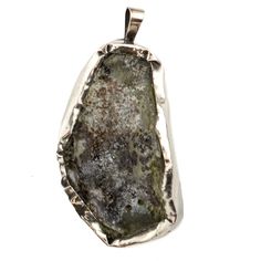 the pendant is made out of silver and has a large piece of green moss on it