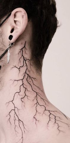 the back of a woman's neck with lightning tattoo on it