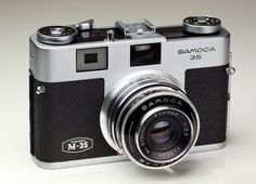 a silver and black camera sitting on top of a table