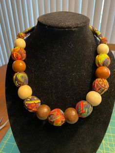 A handmade cotton fabric necklace with wooden beads.  Full length is 36", but when tied it is approximately 24".  You may tie it tighter to get it down to about 20".  Beads are approximately 3/4" width.  The fabric is cotton with a rainbow geometric design on it that's really fun - some floral thrown in for good measure.  Great, chunky, bright piece.  Note that you have to tie it yourself, there is no clasp.  Also note:  the color with the green background is most accurate Colorful Adjustable Necklaces With Wooden Beads, Adjustable Rainbow Beaded Necklaces With Wooden Beads, Adjustable Rainbow Beaded Necklace With Wooden Beads, Adjustable Multicolor Wooden Beaded Necklaces, Fabric Necklaces Ideas, Fabric Necklaces, Necklaces Ideas, Arlington Va, Fabric Necklace