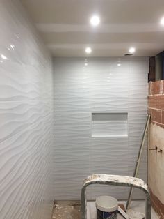 an unfinished bathroom with white walls and tile on the floor, including a bucket for paint